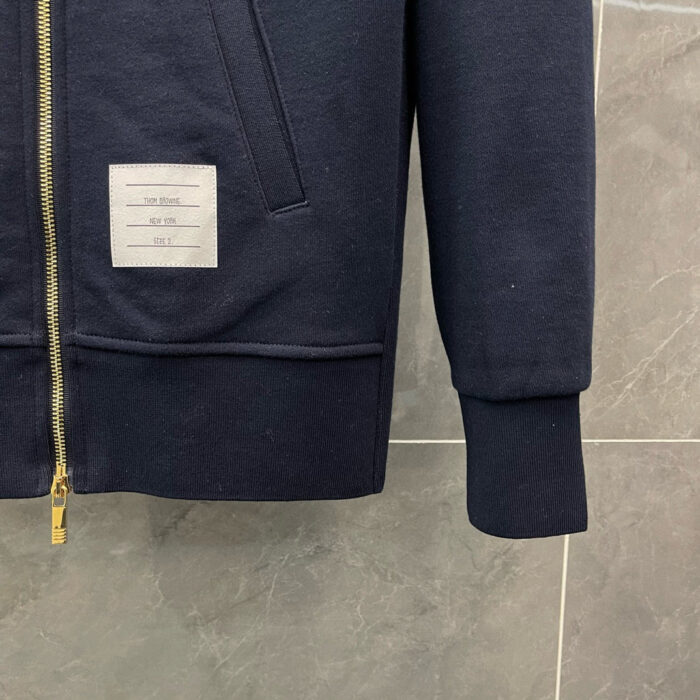 Felpa blu navy con zip metallico, dettaglio etichetta bianca, interno morbido, stile casual e moderno.