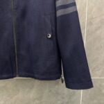 Giacca navy textured con bottoni metallici, tasca, dettagli riflettenti e design sportivo.