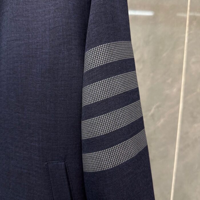 Gambale di giacca navy con strisce grigio moderne, design elegante e dettagli sofisticati.