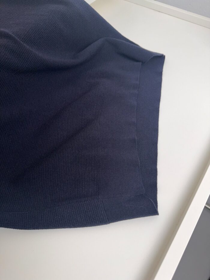 Tessuto in lana navy, morbido e elegante, con dettagli a coste e finitura curata.