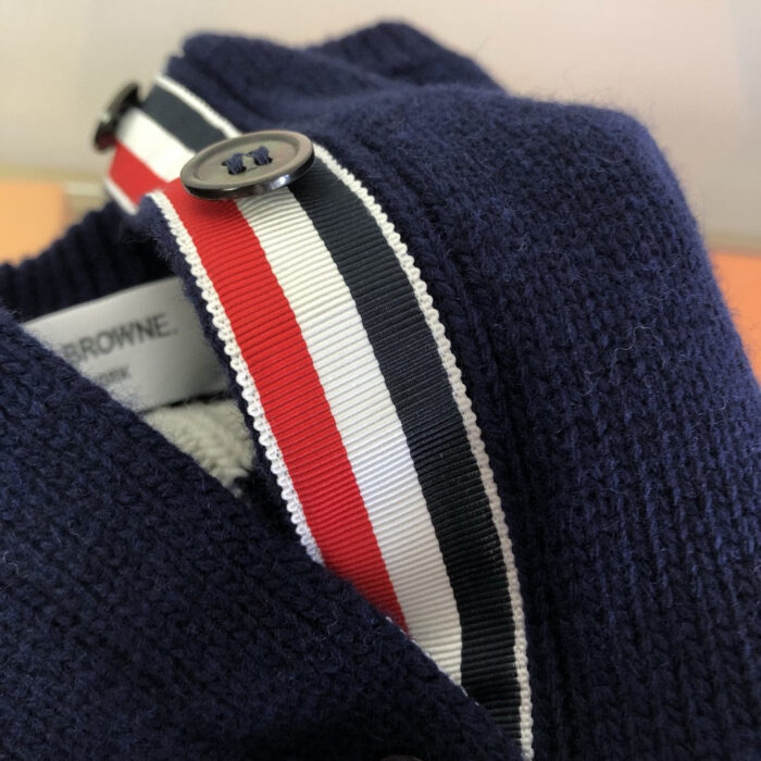 Giacchetto blu navy con colletto a mèches, bottone e dettaglio di alta qualità.