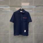 Maglietta polo navy uomo, elegante e versatile, con taschino a contrasto e dettagli a strisce.