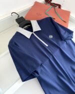Polo navy con colletto contrasto, logo elegante e tessuto traspirante, perfetta come regalo raffinato.