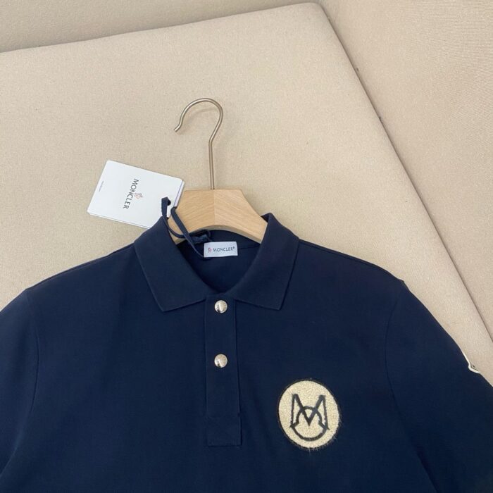 Maglietta polo navy con ricamo logo M, stile raffinato, cotton morbido, perfetta per ogni occasione.