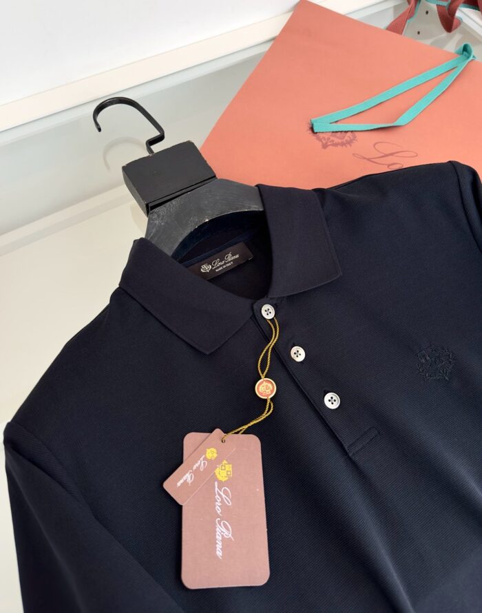 Camicia polo navy con tag rosa, sfondo pastel e dettagli di moda eleganti.
