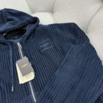 Felpa navy con cappuccio, zip in metallo e motivo a costina, stile elegante e casual.