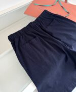 Pantaloncini navy blu con tasche e regalo colorato, stile casual e versatile.