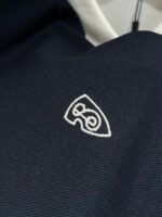 Maglietta navy con logo bianco ricamato, tessuto resistente e stile moderno casual.