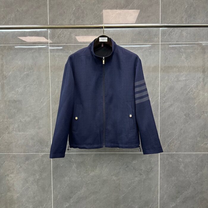 Giacca navy minimalista con strisce sportive, colletto alto e dettagli eleganti in blu scuro.