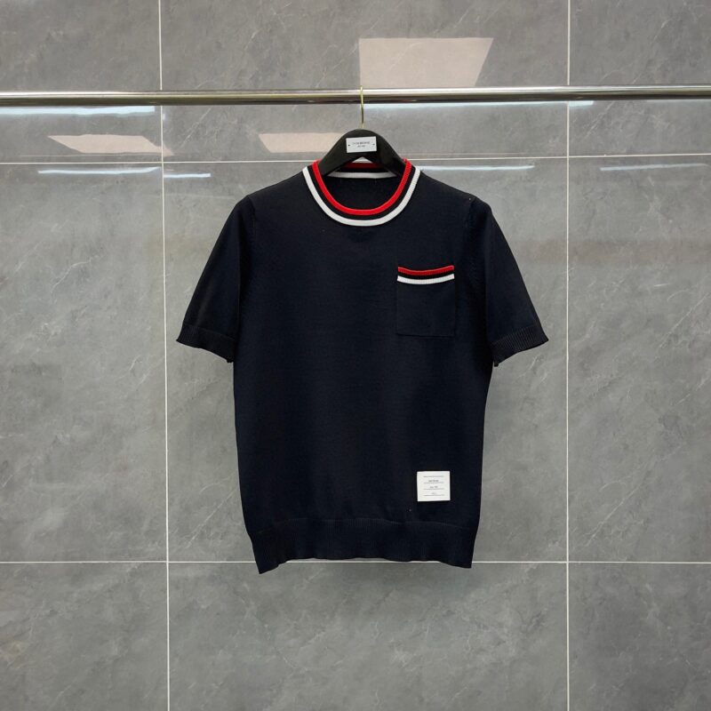 Camicia corta in maglia navy con colletto a righe rosso e bianco, stile casual e moderno.