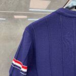 Maglione navy con spalle a strisce rosso, bianco e blu, stile sportivo e design elegante.