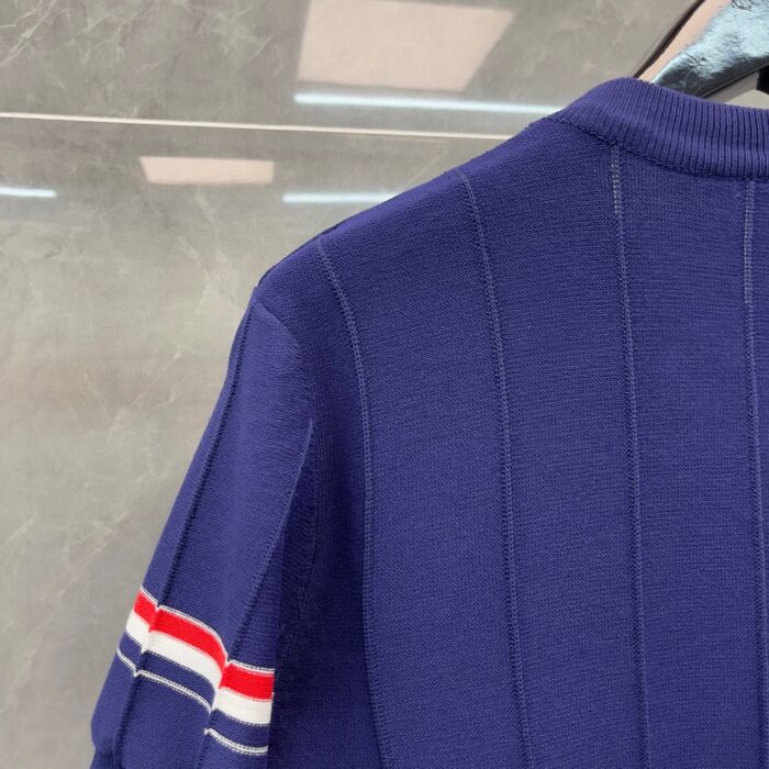 Maglione navy con spalle a strisce rosso, bianco e blu, stile sportivo e design elegante.