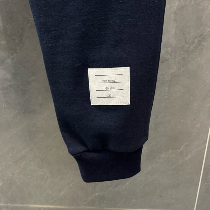 Pantaloni jogger blu navy con etichetta minimalista e elastico agli orli, perfetti per casual sportivi.