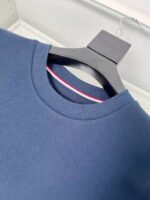 Maglietta navy con dettaglio colorato e colletto a giro, elegante e versatile.