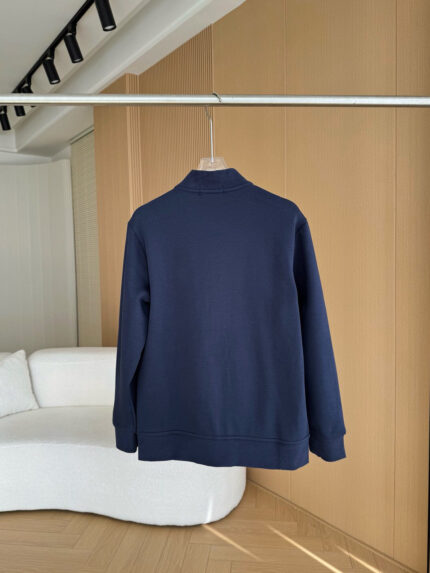 Felpa navy semplice e elegante in ambiente moderno con arredi in legno e luce naturale.