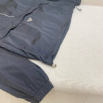 Giacca a vento blu navy sportiva, moderno design con logo riflettente e polsini elasticizzati.