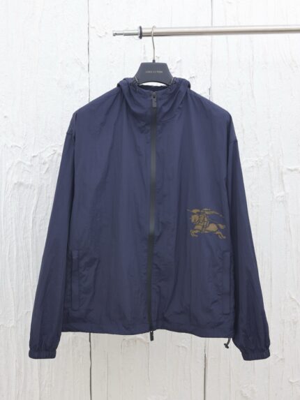 Giacca leggera navy con zip, high collar e dettaglio decorativo sul petto.