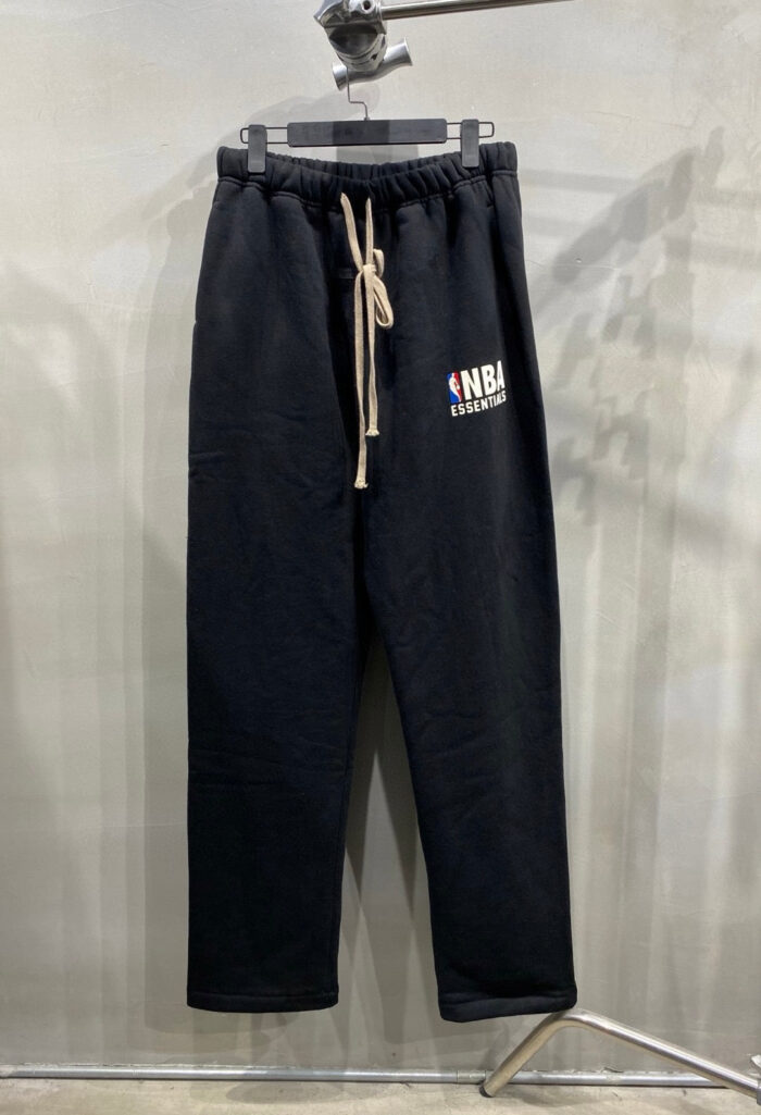 Pantaloni jogger neri NBA, comodi, con logo colorato e elastico in vita, stile casual moderno.