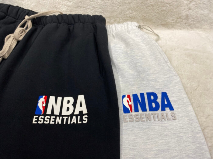Pantaloni sportivi NBA Essentials nero e grigio, comodi, con logo e vita regolabile.