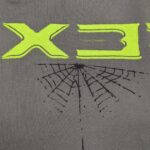 T-shirt con grafica rete di ragno e scritta neon verde, stile streetwear moderno e originale.