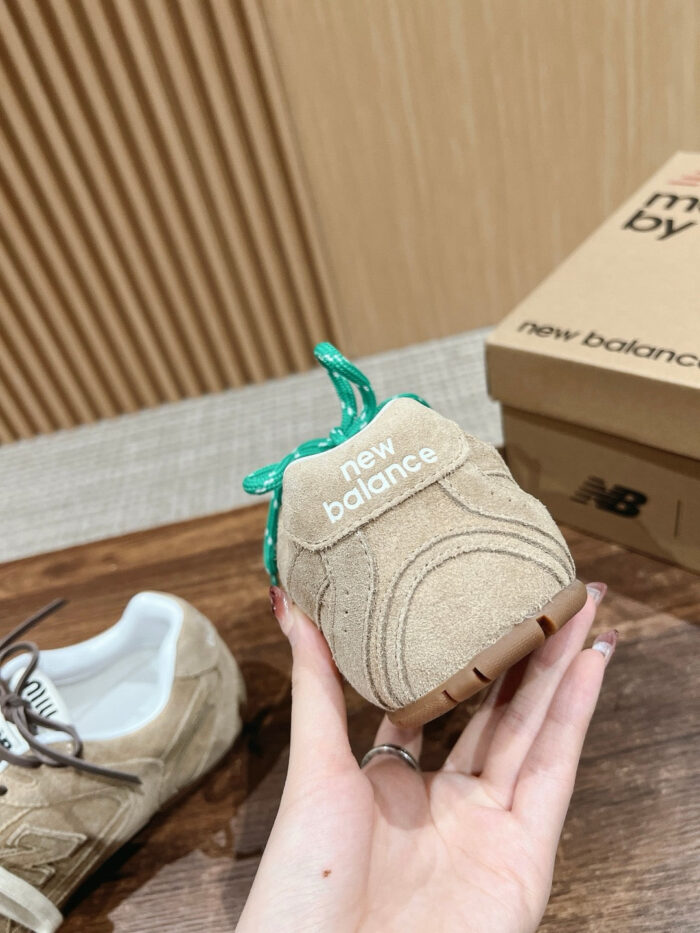 Scarpa New Balance in suede tortora con lacci turchese, stile moderno e comfort.