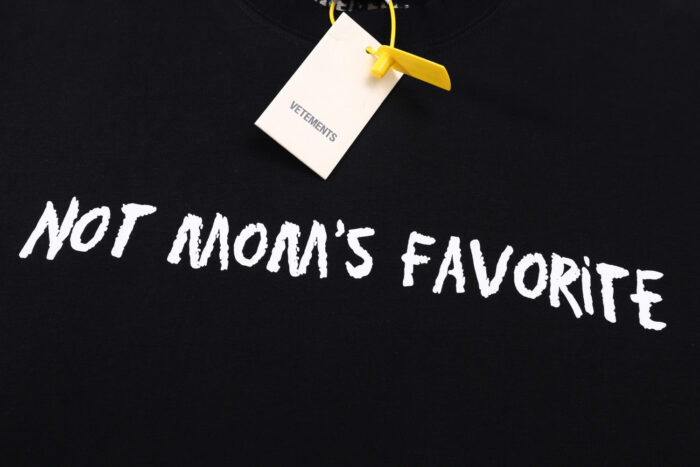 Maglietta nera umoristica con scritta Non sono la favorita della mamma in stile giocoso.