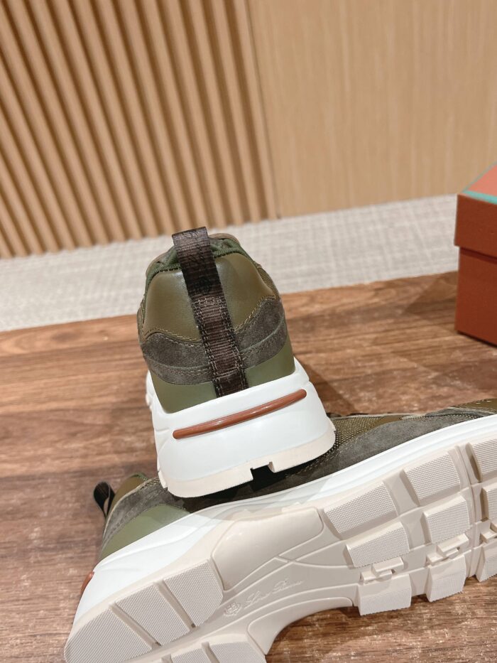 Sneaker verde oliva con suola bianca, dettagli moderni su superficie di legno, stile urbano e trendy.
