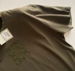 T-shirt verde oliva casual con ricamo artistico, perfetta per look semplici e moderni.