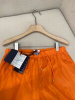 Pantaloncini estivi arancioni in tessuto leggero e rapido, perfetti per mare e vacanze.