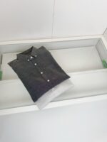 Camicia grigia elegante piegata in cassetto moderno e ben organizzato.