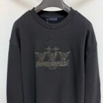 Felpa nera oversize con logo gioiello metallizzato, stile streetwear e design elegante.