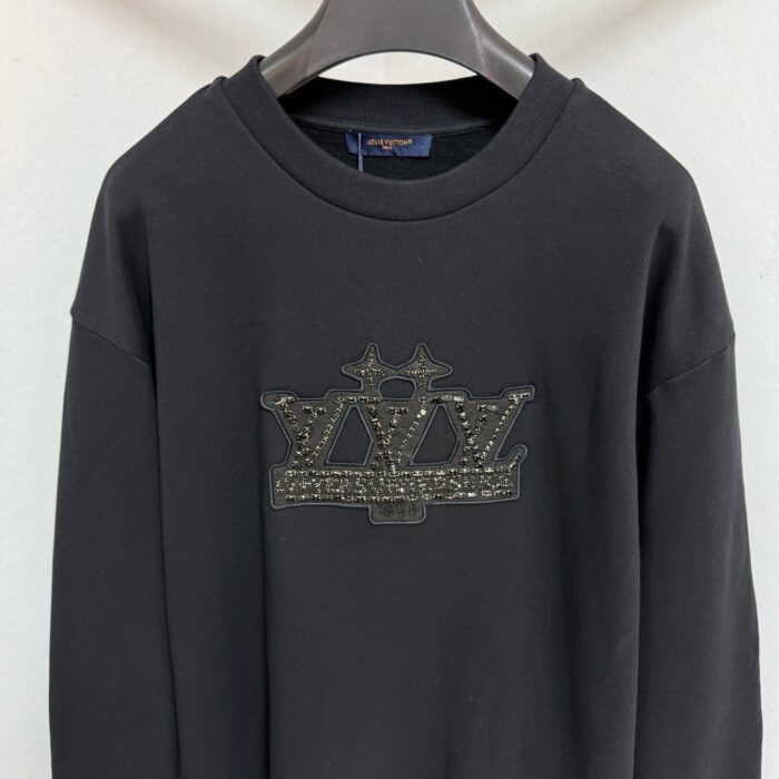 Felpa nera oversize con logo gioiello metallizzato, stile streetwear e design elegante.