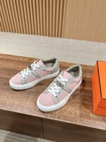 Sneaker trendy rosa e verde su superficie in legno con dettagli bianchi, stile casual e moderno.
