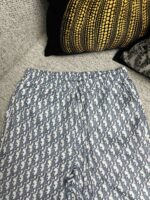 Pantaloni a motivi blu e bianco su divano con cuscini decorativi eleganti e confortevoli.