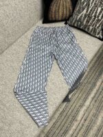 Pantaloni estivi a motivo blu e bianco su divano grigio, stile casual e confortevole.