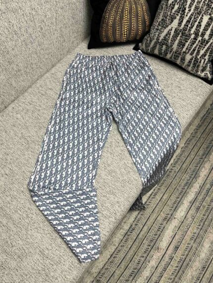 Pantaloni estivi a motivo blu e bianco su divano grigio, stile casual e confortevole.