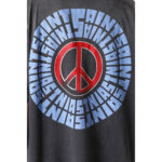 T-shirt nero con simbolo della pace rosso e scritta SAINTS blu curva, stile casual e youthful.