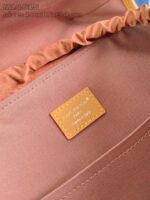 Interno di borsa elegante con dettagli ricamati, tessuto color pesca e etichetta di qualità.