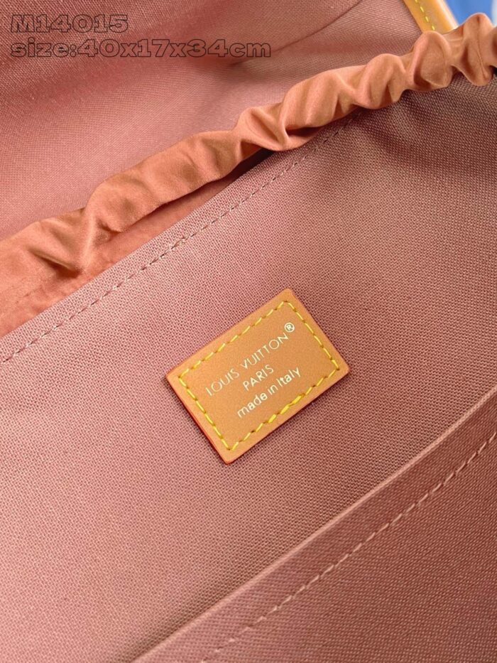 Interno di borsa elegante con dettagli ricamati, tessuto color pesca e etichetta di qualità.