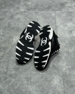 Scarpe sportive nere e bianche di alta qualità con design dinamico e logo elegante.