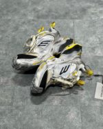 Scarpe sportive argentate con dettagli gialli, suola robusta e design ergonomico per alte prestazioni