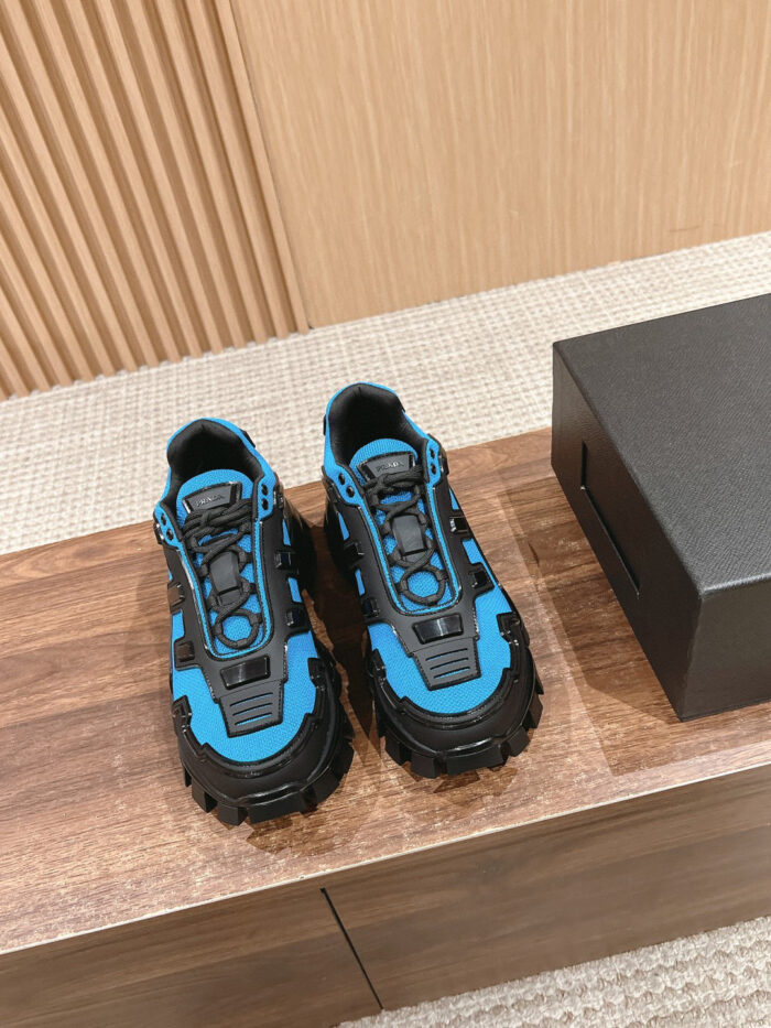 Scarpe da outdoor blu e nere, sporty e resistenti, su superficie di legno con scatola nera.