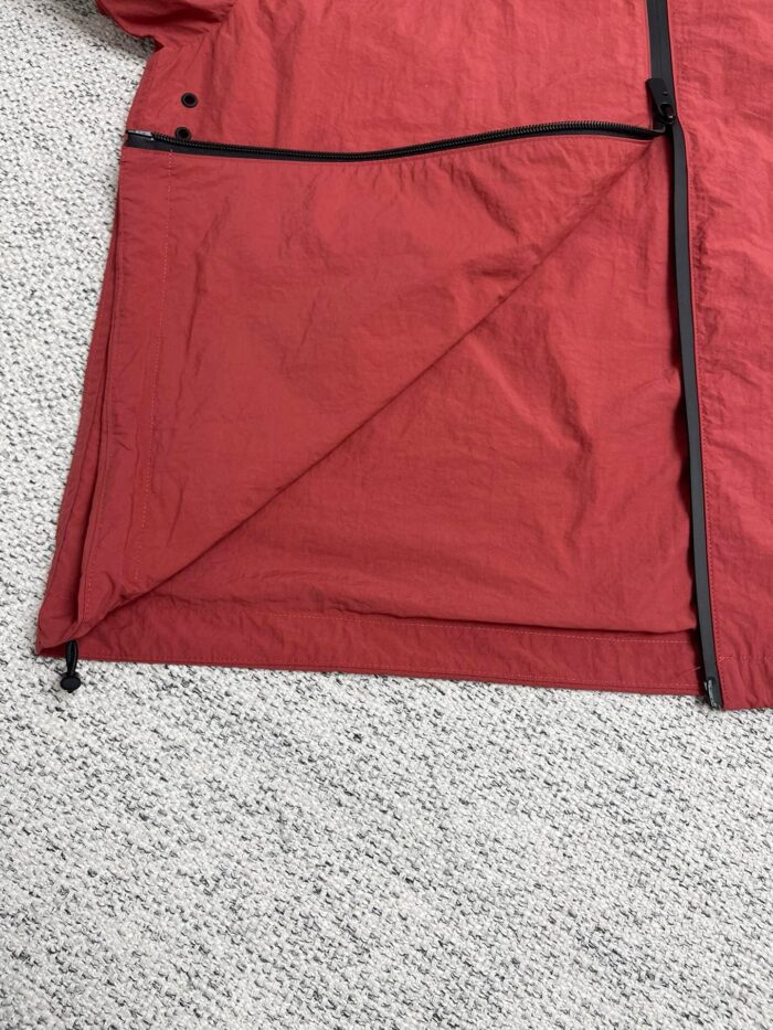 Giacca rossa sportiva impermeabile con zip resistente, ideale per attività allaperto e visibilità.