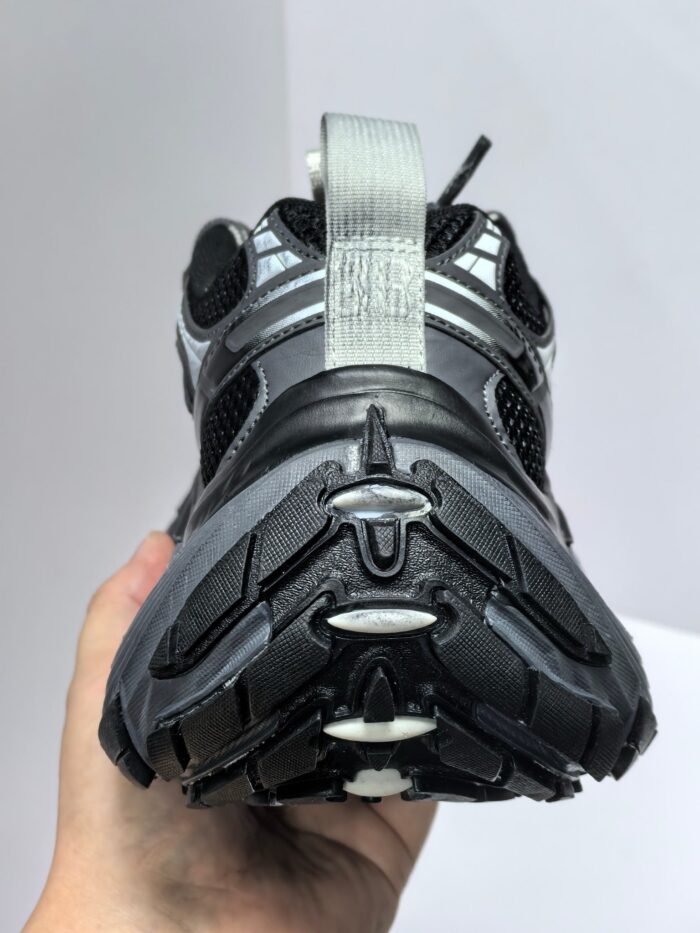 Sneaker sportiva nera con dettagli grigi, suola antiscivolo e supporto per attività atletiche.