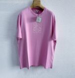 Maglietta rosa casual con ricamo floreale bianco, tessuto leggero e stile minimalista elegante.