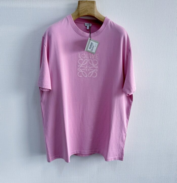 Maglietta rosa casual con ricamo floreale bianco, tessuto leggero e stile minimalista elegante.