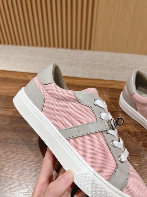 Scarpe sportive rosa e grigio con design moderno e lacci innovativi, perfette per stile e comfort.