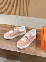 Scarpe da ginnastica rosa in camoscio con suola bianca, stile casual e trendy.