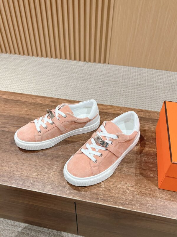 Scarpe da ginnastica rosa in camoscio con suola bianca, stile casual e trendy.
