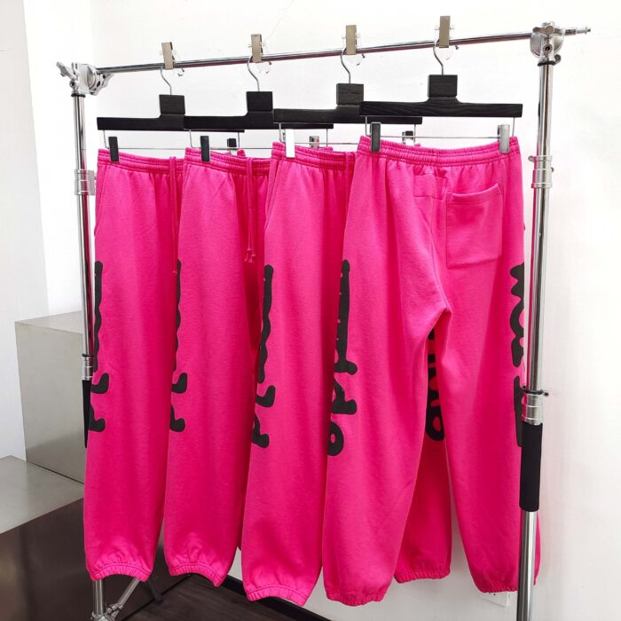 Pantaloni sport rosa con lettere nere, stile urban chic, perfetti per un look trendy e comodo.